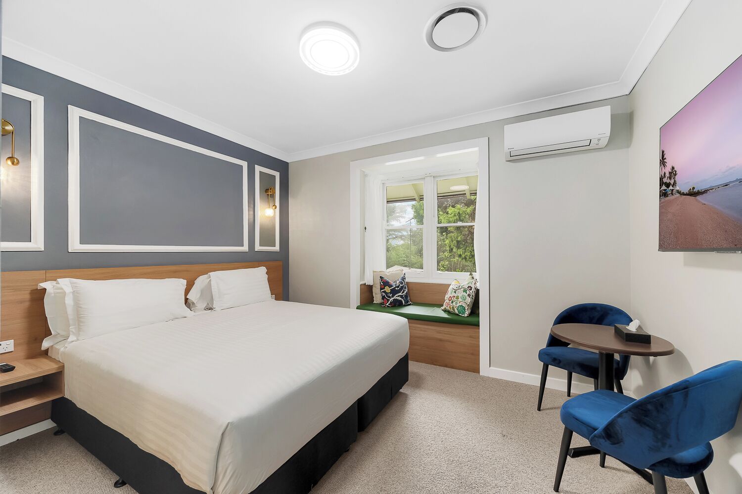 Une chambre d’hôtel moderne équipée d’un lit, d’un bureau, d’une chaise, d’une fenêtre avec vue et d’un appareil de climatisation.
