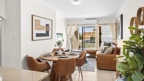A dining area with a round table, chairs, and a sofa. - Kiahuna 2 (uMhlanga)