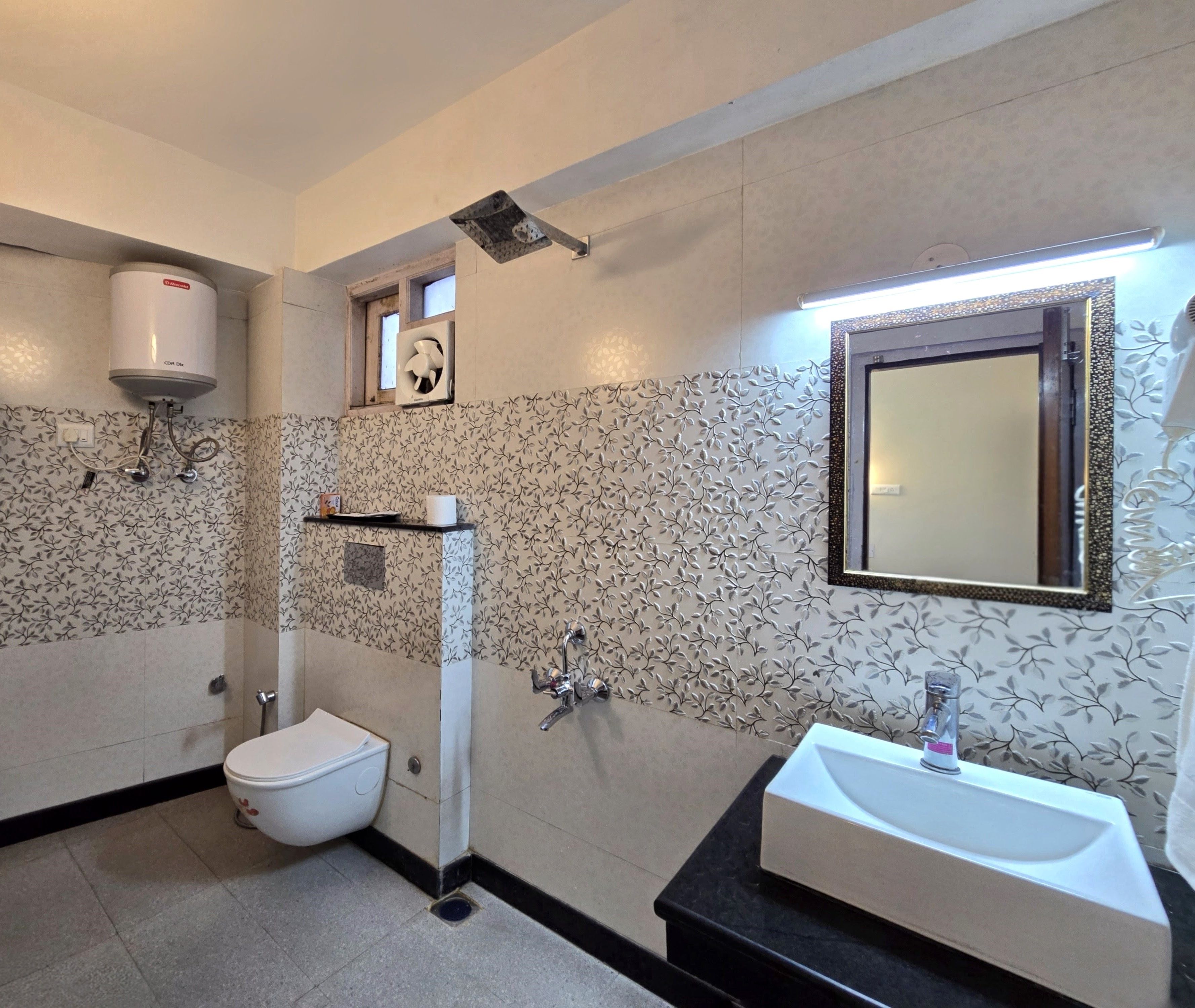 Un baño con inodoro, ducha y lavamanos.