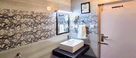 A modern bathroom with a vanity, a shower, and a toilet.