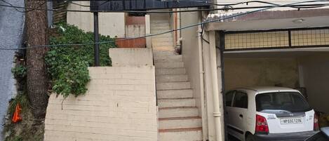 A hotel sign, a staircase, and a parked car.