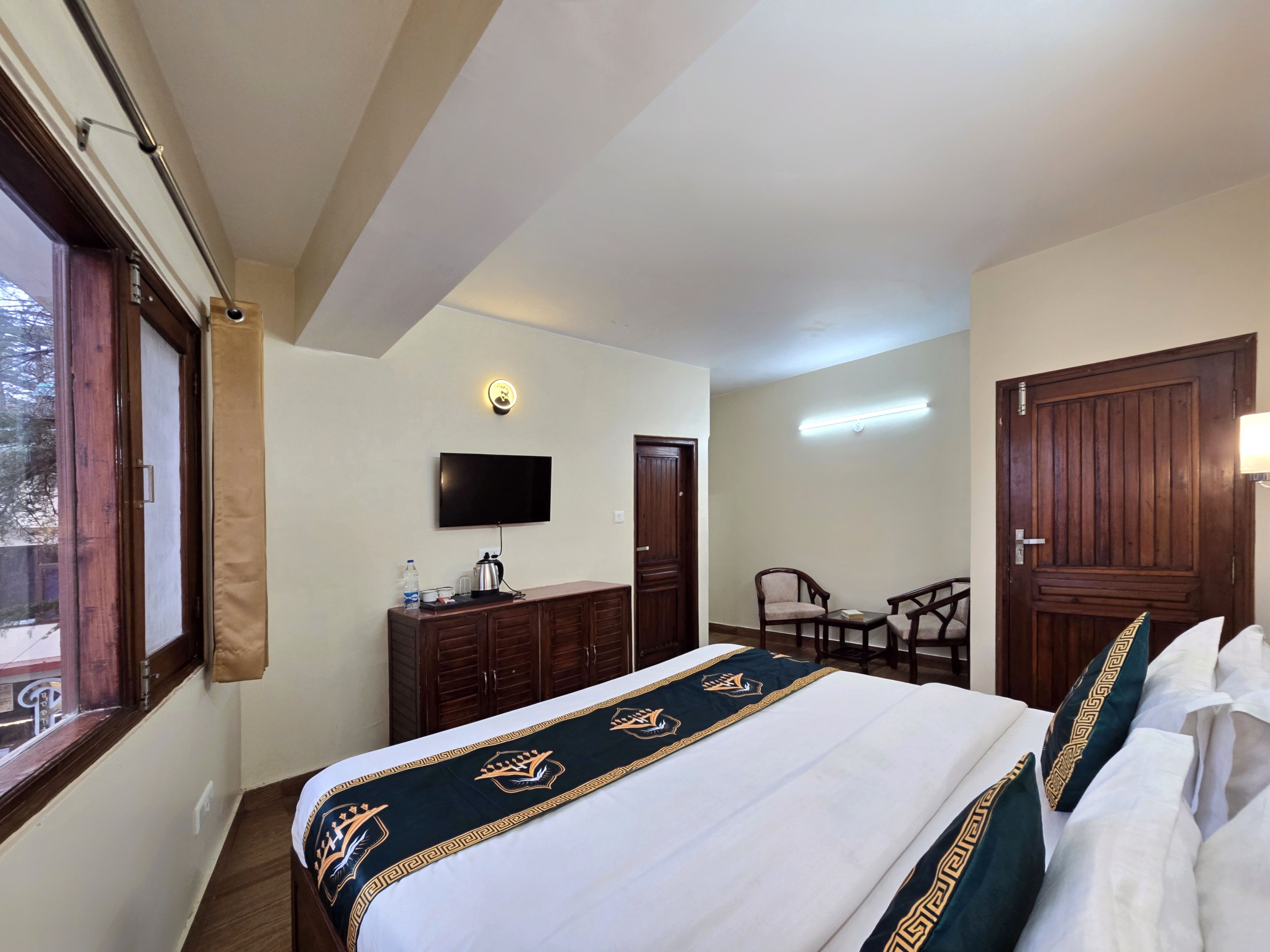 Ein Hotelzimmer mit Bett, Fernseher, Schreibtisch mit Stuhl und Kleiderschrank.
