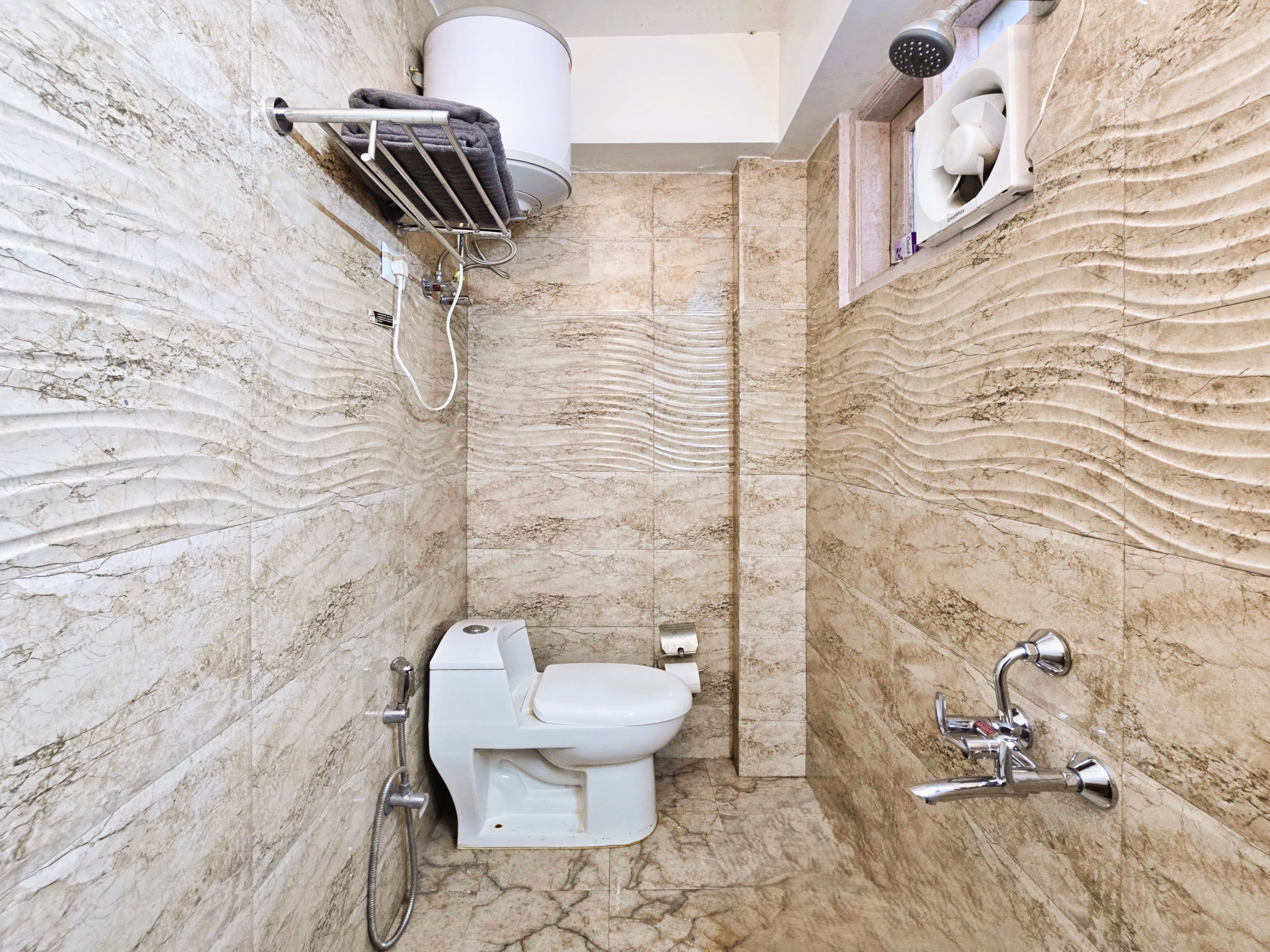A bathroom with a toilet, shower, and towel rack.