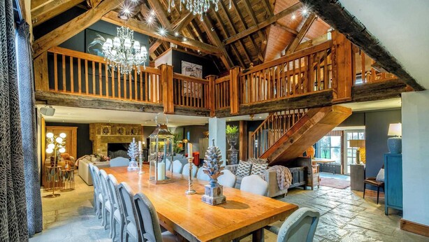 A spacious dining area with a high wooden ceiling, a chandelier, and a staircase leading to an upper level. - Willowberry Barn - Exclusive Home with Hot Tub (Weston Subedge)