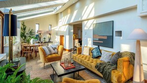 A modern living room with a sofa, armchairs, a coffee table, and a dining area with chairs and a table. - Willowberry Barn - Exclusive Home with Hot Tub (Weston Subedge)