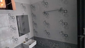 Une salle de bain avec un miroir, un lavabo et un porte-serviettes.