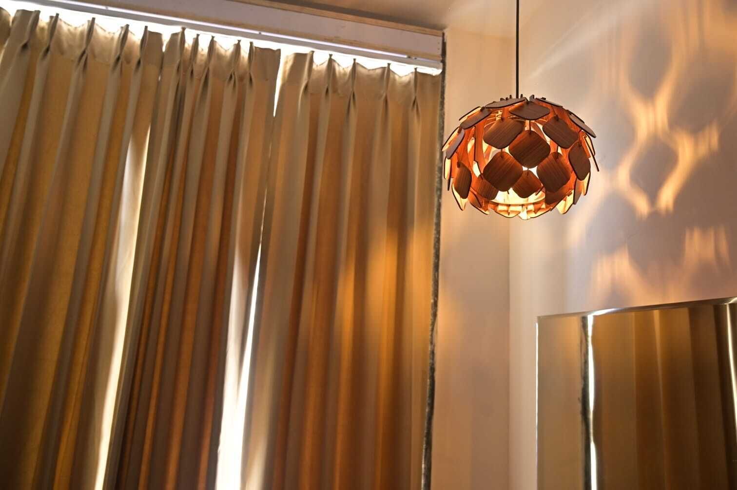 Quarto com uma grande janela, luminária pendente e espelho fixado na parede.