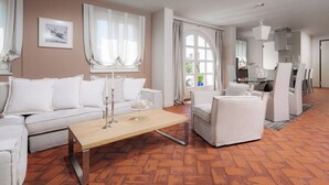 A modern living room with a sofa, armchairs, a coffee table, and a dining area with chairs and a glass table. - Villa Pia by Nova Villas (Vabriga)