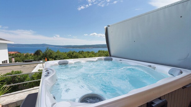 Un jacuzzi con vistas despejadas al mar y colinas lejanas.