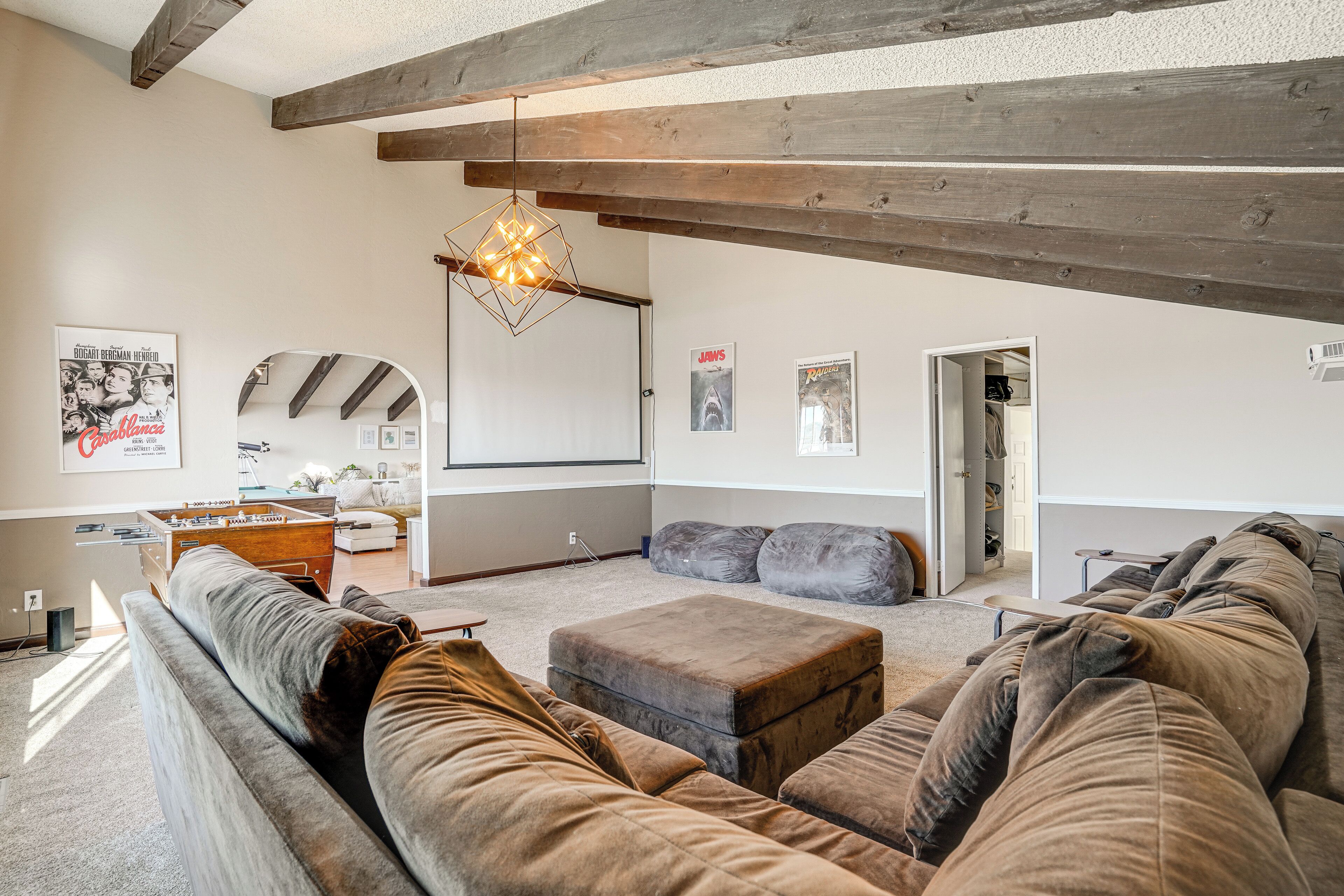 Ein Wohnzimmer mit einer Couch, einem Hocker und einer Pendelleuchte.