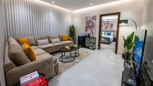 Ein modernes Wohnzimmer mit einer Couch, einem Couchtisch und Kunstwerken.