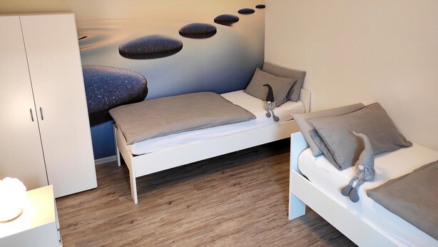 A bedroom with a bed, bedside tables, a wardrobe, and a wall mural. - Casa Wohnen und Wellness: Private Terrace, Garden, Wi-Fi, Direct Forest Access (Hemer)