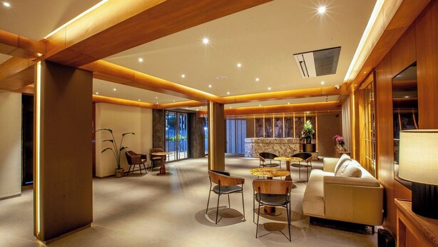 A spacious hotel lobby with a central seating area, a reception desk, and a large window offering a view of the outdoors. - Purple Elephant Luxury Business Hotel (Kanayannur)