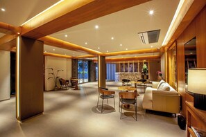 A spacious hotel lobby with a central seating area, a reception desk, and a large window offering a view of the outdoors. - Purple Elephant Luxury Business Hotel (Kanayannur)