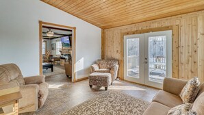 A cozy living room with a patterned rug, a sofa, a chair, and a wooden ceiling. - The Farm by the Chain of Lakes: Walk to the Beach! (Alexandria)