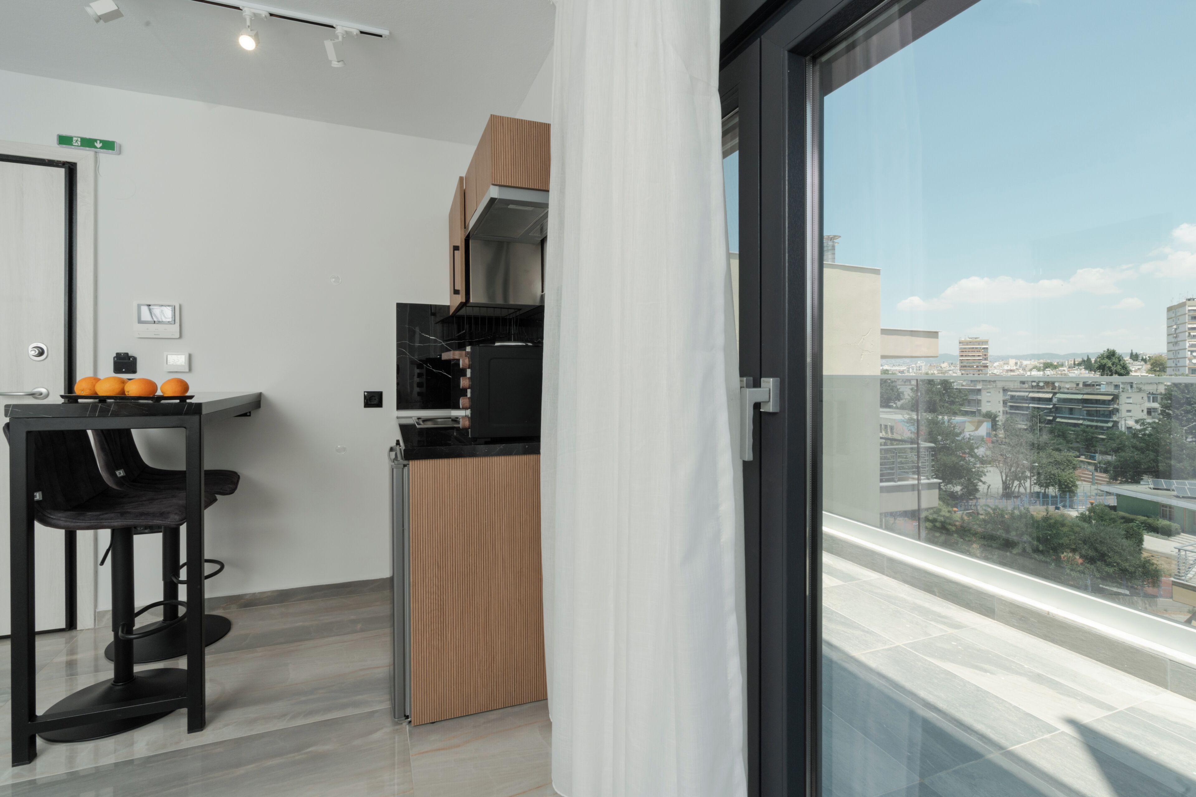 Eine moderne Küche mit Blick auf die Stadt, ein Essbereich mit Stühlen und ein großes Fenster.