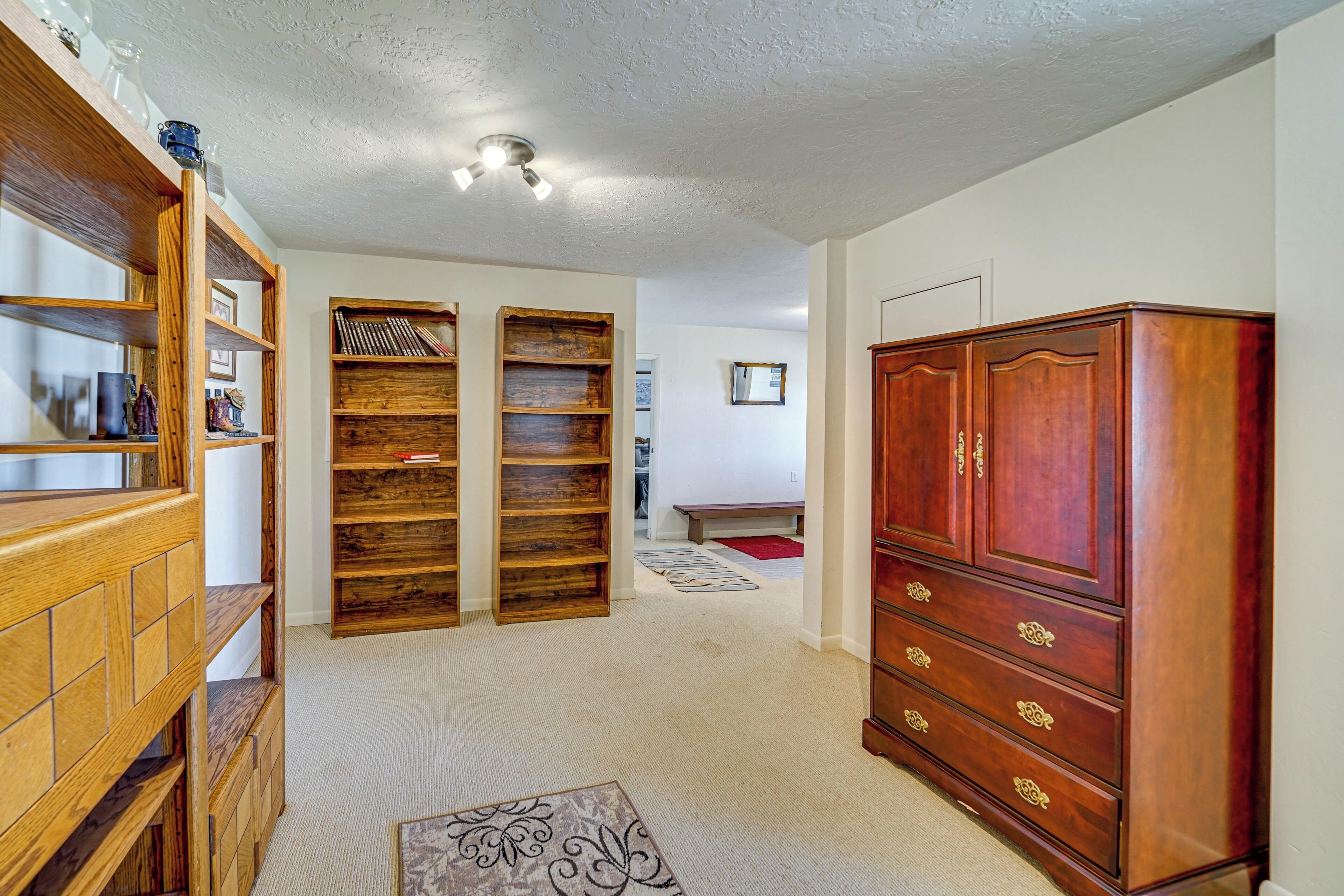 A room with a wooden cabinet, a bookshelf, and a carpeted floor.