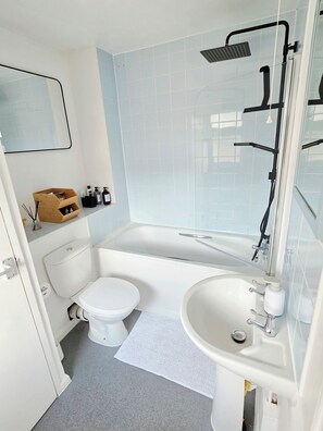 Ein modernes Badezimmer mit Badewanne, Toilette und Waschbecken.