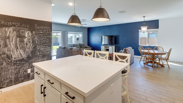 A modern kitchen with a chalkboard, white cabinetry, and pendant lighting. - Near Golf, Parks & Casino! Updated Maricopa Home (Maricopa)