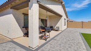 A covered patio area with a grill, outdoor seating, and a paved walkway. - Near Golf, Parks & Casino! Updated Maricopa Home (Maricopa)