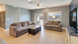 A living room with two sofas, a coffee table, a ceiling fan, and a TV. - Near Golf, Parks & Casino! Updated Maricopa Home (Maricopa)