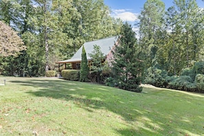 A house surrounded by a well-maintained lawn and dense trees. - < 1 Mi to Lake Blue Ridge: Forest-view Gem w/ Deck (Morganton)