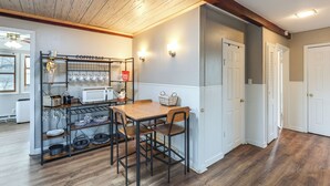 A kitchen with a coffee bar, wooden chairs, and a white door. - Warren County Launchpad: Pet-friendly Lebanon Apt (South Lebanon)