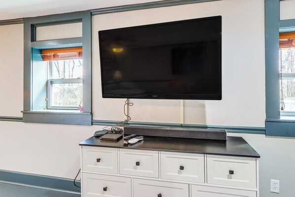 A room with a mounted television, a white dresser, and a window with blinds. - Blue Ridge Escape With On-site Pool Access (Epworth)