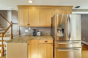 A kitchen with wooden cabinets, a stainless steel refrigerator, and a granite countertop. - Hike, Bike & Relax: Huckleberry Hill Home w/ Yard! (Avon)