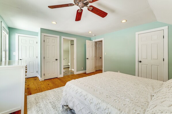A bedroom with a bed, a ceiling fan, and white doors. - Hike, Bike & Relax: Huckleberry Hill Home w/ Yard! (Avon)