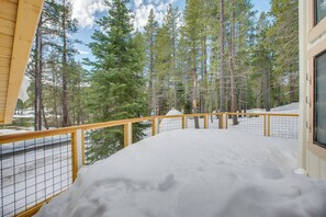 A snow-covered deck with a wooden railing, surrounded by tall pine trees. - 5 Mi to Soda Springs Mtn Resort: Forest-view Gem! (Truckee)