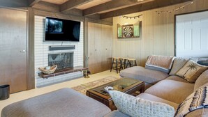 Una sala de estar con chimenea, televisor, sofá y una mesa de centro.