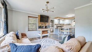 A living room with a sofa, television, and a dining area with chairs and a table. - Deck & Spacious Yard! Wilmington Gem on Half-acre (Wilmington)