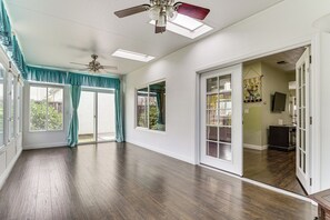 A spacious room with a ceiling fan, large windows with curtains, and a view of the outdoors. - Commuter-friendly Fremont Home Near Tech HQs (Fremont)