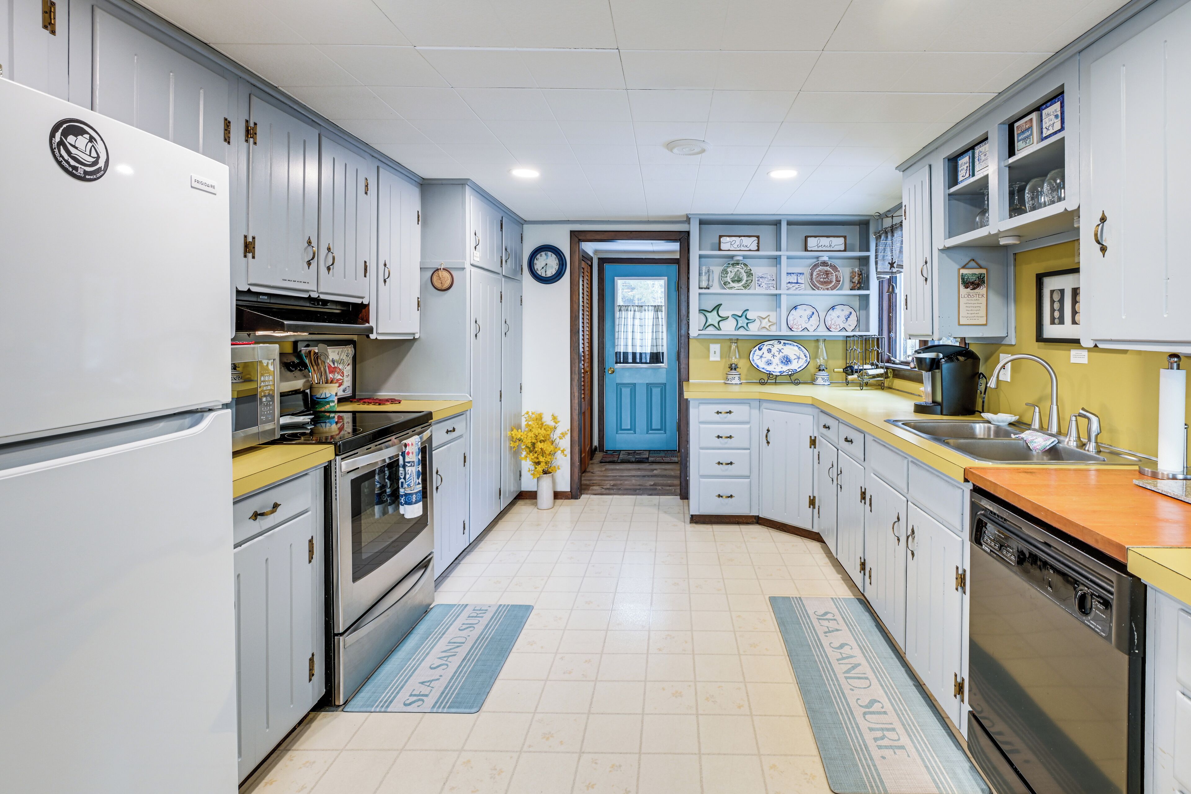 A kitchen with white cabinets, a microwave, a stove, and a dishwasher.