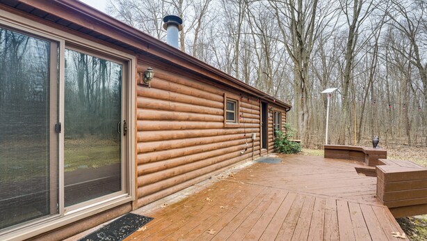 A log cabin with a deck, large sliding glass doors, and a chimney. - Quiet Wooded Escape! Metro Detroit Basecamp (Romulus)