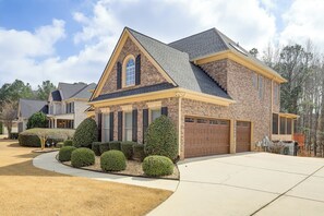 A two-story house with a brick facade, a gabled roof, and a garage. - 7 Mi to Arthur Blank & Trilith Studios: Cozy Suite (Tyrone)