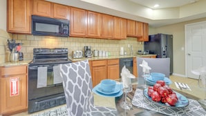 A kitchen with wooden cabinets, a microwave, stove, and a refrigerator. - 7 Mi to Arthur Blank & Trilith Studios: Cozy Suite (Tyrone)