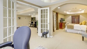 A spacious room with a large bed, a desk, and a chair. - 7 Mi to Arthur Blank & Trilith Studios: Cozy Suite (Tyrone)