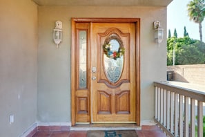 A wooden front door with a glass panel, a doormat, and a white railing. - Great Location & Free Extras! Bellflower Stay (Bellflower)