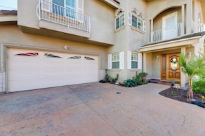 A two-story house with a garage, a front door, and a small garden area. - Great Location & Free Extras! Bellflower Stay (Bellflower)