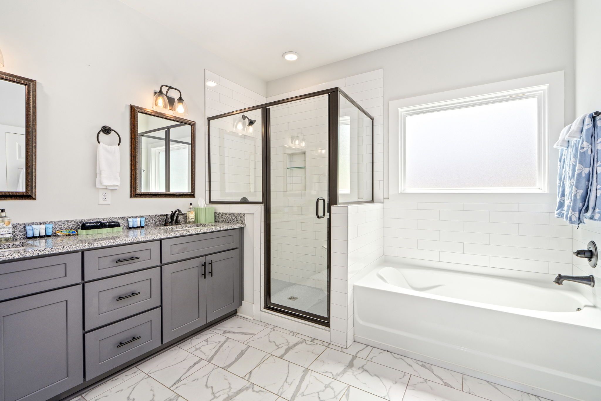 A modern bathroom with a walk-in shower, a bathtub, and a vanity with a mirror.