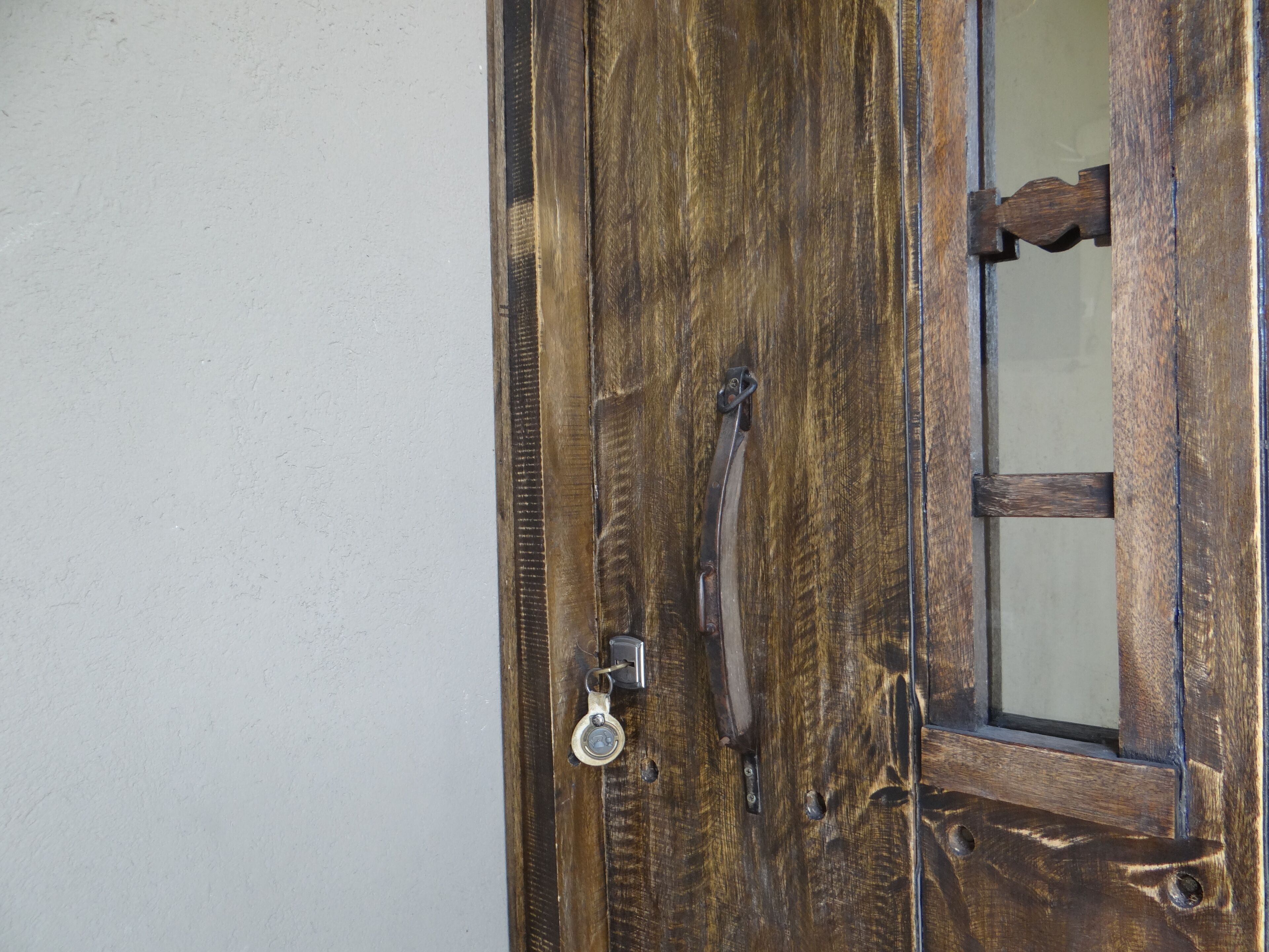 A wooden door with a metal handle and a keyhole.