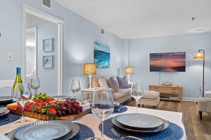A modern living room with a dining area, featuring a sofa, coffee table, and a flat-screen TV. - Family Friendly Resort w/ Pools, Beach, Golf (Hilton Head Island)