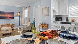 A dining area with a table set for four, a bottle of wine, and a fruit platter. - Family Friendly Resort w/ Pools, Beach, Golf (Hilton Head Island)