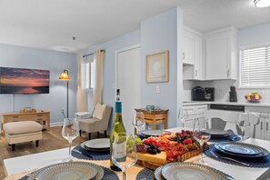 A dining area with a table set for four, a bottle of wine, and a fruit platter. - Family Friendly Resort w/ Pools, Beach, Golf (Hilton Head Island)