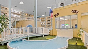 An indoor pool area with a white bridge, American flags, and signs indicating 'GAME' and 'ROOM' areas. - Family Friendly Resort w/ Pools, Beach, Golf (Hilton Head Island)