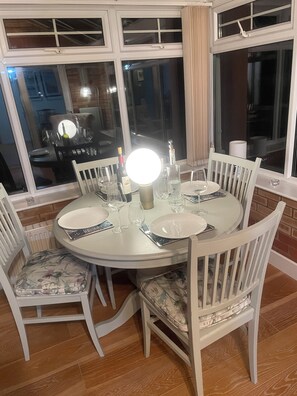 A dining table set for six with white chairs, a round table, and a bright overhead light. - Quiet 4 bedroom home with fast WiFi and parking.
Decorated to a high standard (Newton Flotman)