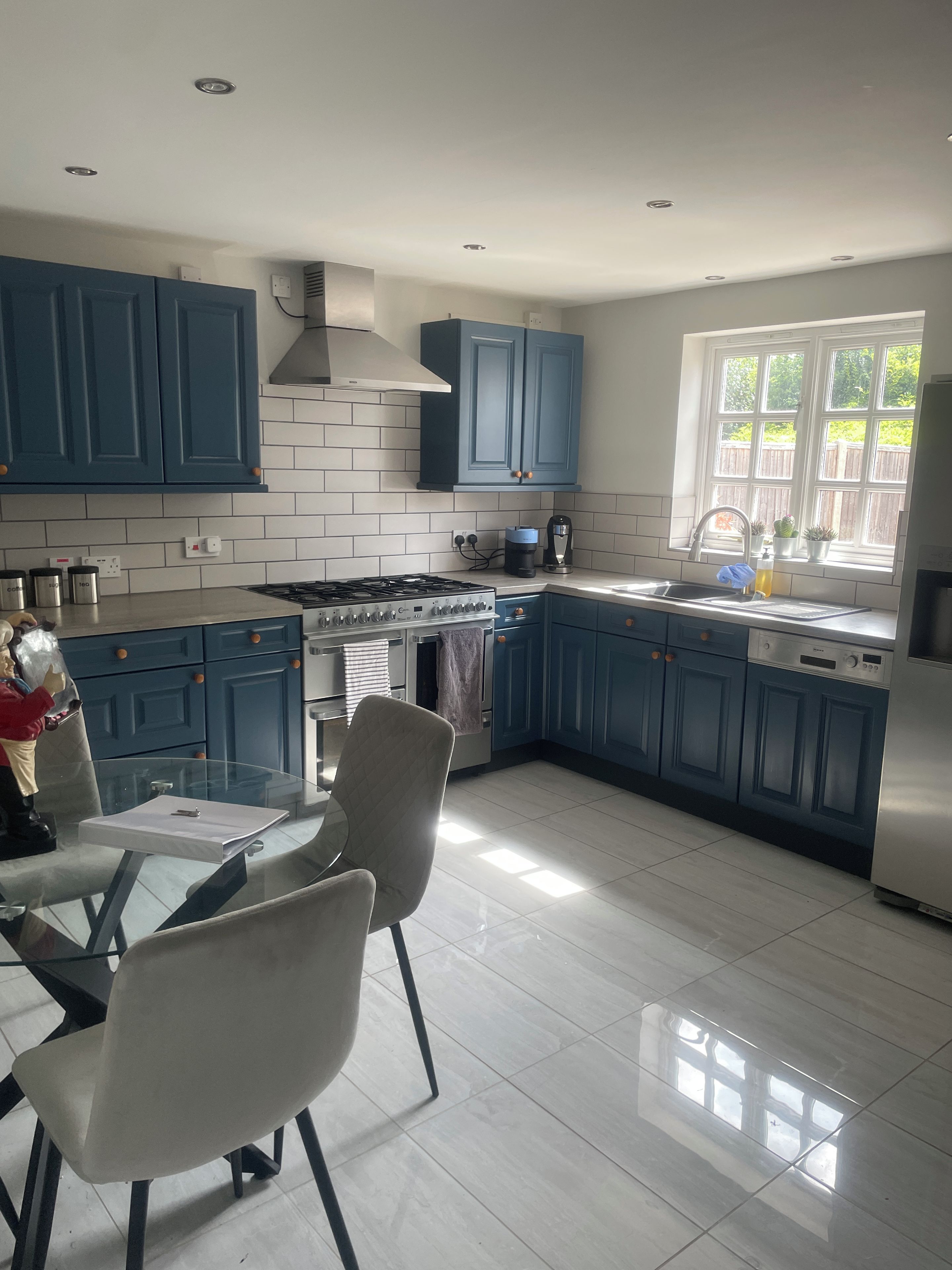 A modern kitchen with blue cabinets, a gas stove, and a dishwasher.