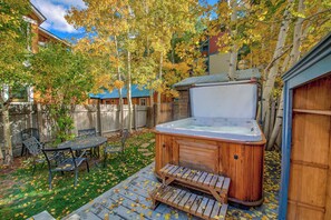 A backyard with a hot tub, wooden deck, and outdoor furniture. - French Street Chalet - Downtown Breckenridge, 30+ Day Rental (Breckenridge)